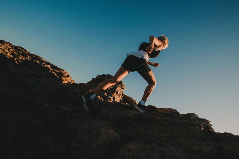 Femme courant au lever du soleil pour un marathon.